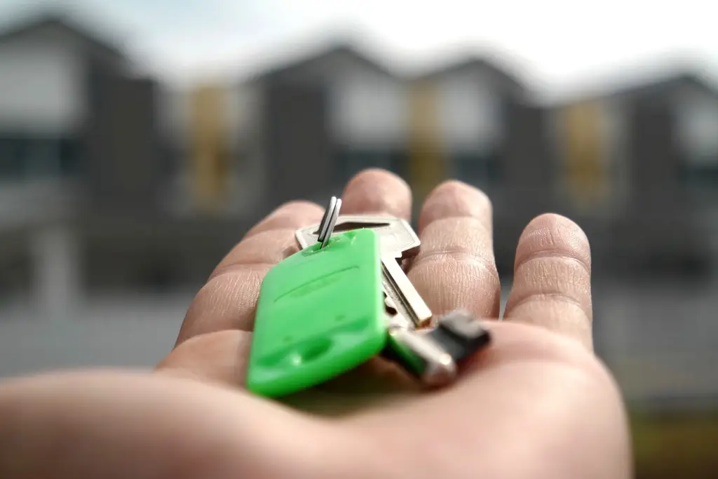 Set of house keys being handed over, representing an owner entrusting their property to a manager